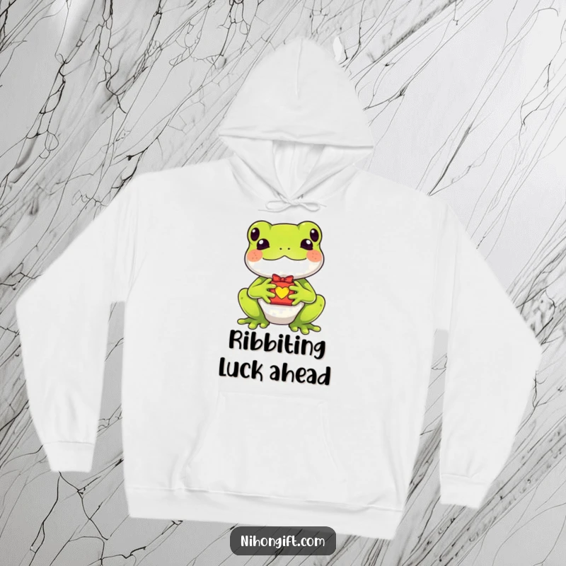 Funny kawaii frog holding a tiny lucky charm gift on a cozy hoodie for whimsical comfort and good luck.